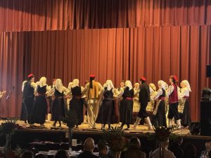 Klub Stepinac dancers in Dalmatian folk costumes dancing a kolo on stage in Mississauga.